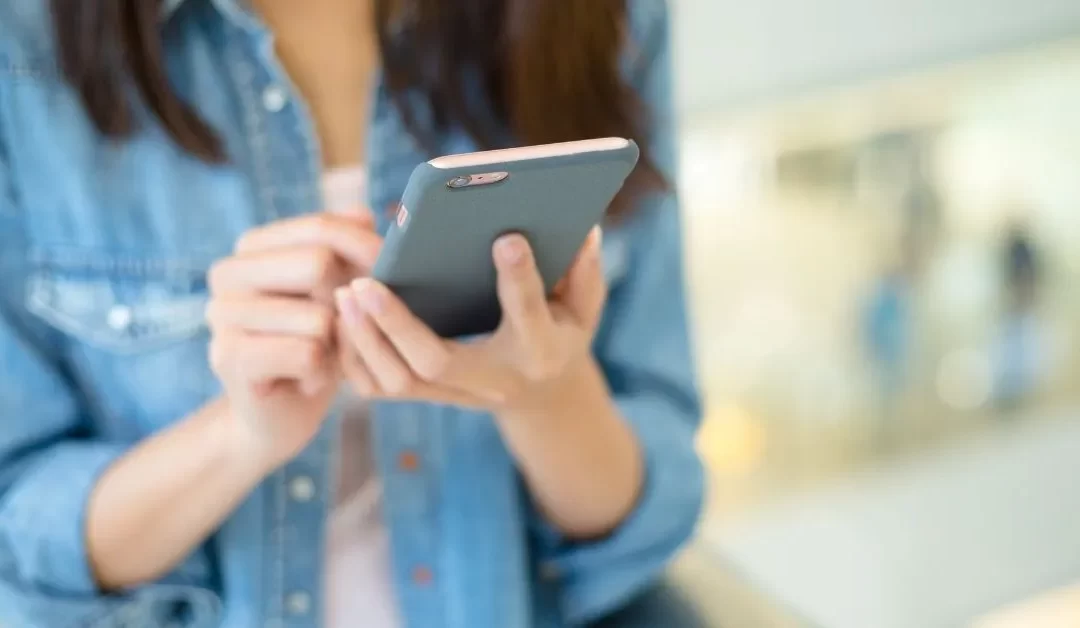 Femme avec un cellulaire dans un aéroport